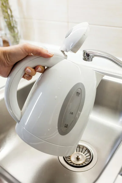 Наливаємо воду в електричний чайник — стокове фото