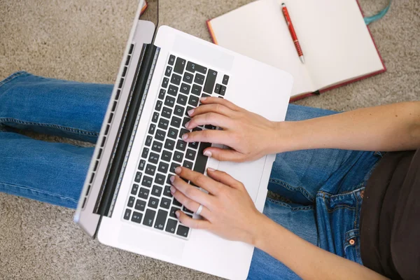 Młoda kobieta korzysta z laptopa w salonie w domu — Zdjęcie stockowe