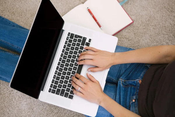 Jonge vrouw met laptop in de huiskamer — Stockfoto