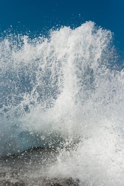 Deniz dalgası beton bir iskeleye çarpar, dikey görünüm