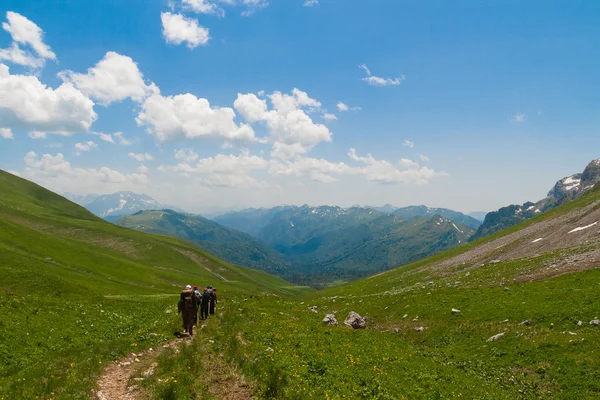 Málo turistů, chůzi po cestě v horách. — Stock fotografie