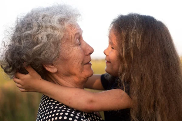 Porträt Einer Großmutter Mit Ihrer Enkelin Bei Sonnenuntergang lizenzfreie Stockbilder
