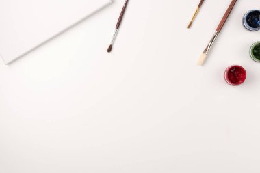 Gouache, fırçalar, beyaz arka planda beyaz tuval. Uzayı kopyala Üst Manzara. Düz yatıyordu.