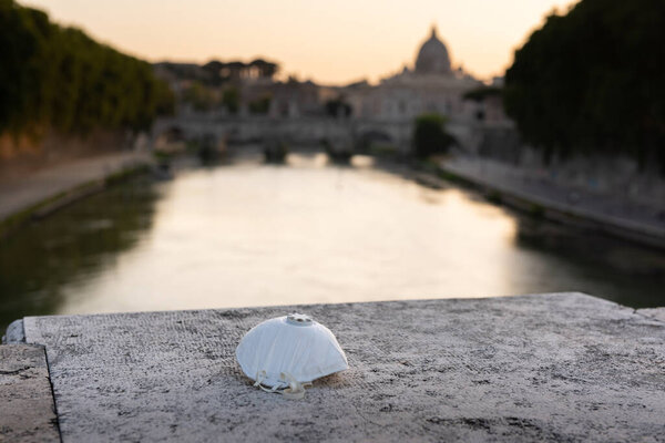 Respiratory protection mask lies on the concrete. Medical mask on the background of the city.