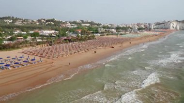 Renkli şemsiyeli ve turkuaz deniz manzaralı harika bir sahil manzarası.