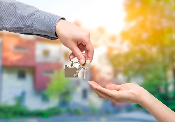 O homem está a entregar uma chave de casa a uma mulher. Conceitos imobiliários . — Fotografia de Stock