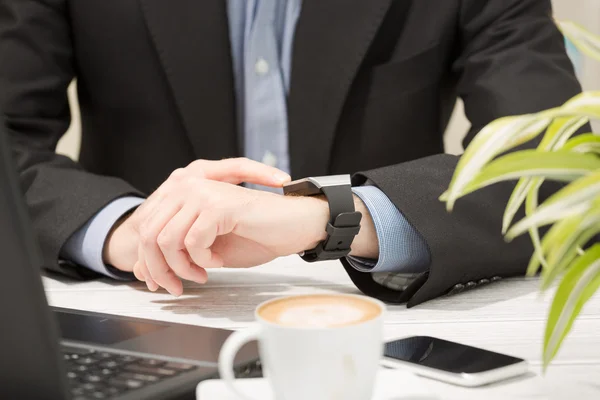 Geschäftsmann nutzt intelligente Uhr und Handy. — Stockfoto