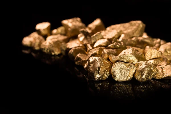 Gold nuggets on black background. — Stock Photo, Image