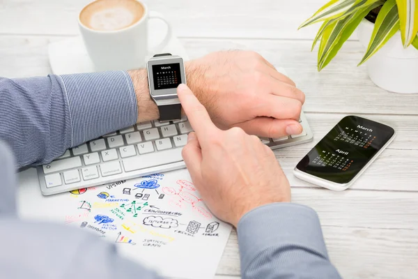 Empresario utiliza reloj inteligente y teléfono . — Foto de Stock