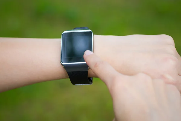 Nő a gazdaság és a touch intelligens watch. — Stock Fotó