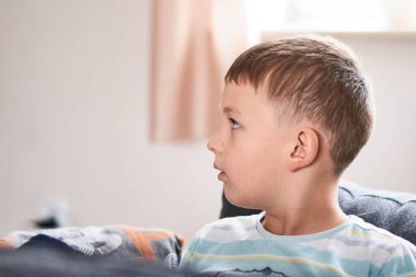 Beyaz okul çocuğu portresi, mavi arka plan.