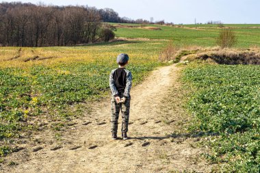 Fieldway 'de kalan ve uzaklardaki mutsuz çocuğu izleyen genç bir çocuk.