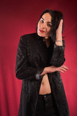 Genç, güzel esmer poz veren, kırmızı arkaplan    