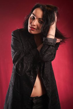 Genç, güzel esmer poz veren, kırmızı arkaplan    