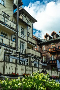 Krynica-Zdroj, Küçük Polonya Voyvoda, Polonya - 08 Ağustos 2025 - Süslü balkonların ve detaylı balkonların yer aldığı tarihi ahşap villalar, yerel spa mimarisinin karakteristik özellikleri, bulutlu bir yaz gökyüzüne karşı görüldü.