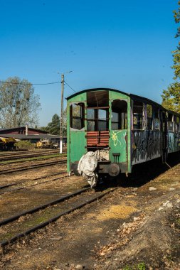 Yıpranmış yolcu vagonu terk edilmiş bir tren istasyonunda kullanılmamış rayların üzerinde grafiti ile kaplanmış..