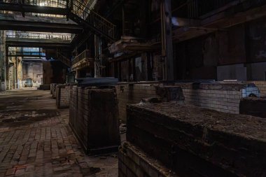 Terk edilmiş fabrikanın içinde tuğla endüstriyel yapılar ve ağır bozulma belirtileri görülüyor..