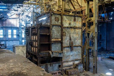 Büyük terk edilmiş fabrika içi çelik sütunlar tuğla duvarlar ve görünür yapısal bozulmalar.