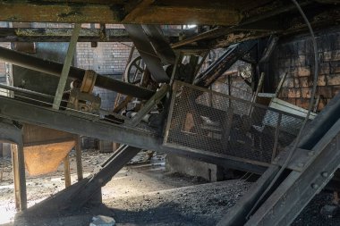 Metal iskelet bantları ve toz ve çürümeyle kaplı endüstriyel bileşenleri olan terk edilmiş taşıma makinelerinin yakın görüntüsü