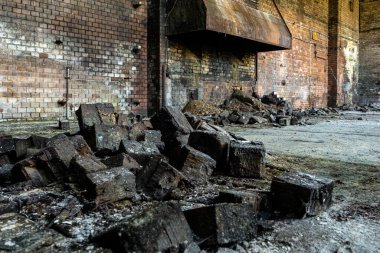 Terk edilmiş sanayi bölgesinde tuğla duvarlar ve çürümüş ağır kömür atıkları var.