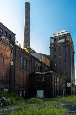 Tekrarlanan geometri ve yıpranmış yüzeylerle terkedilmiş bir endüstriyel merdiven boşluğuna bakın