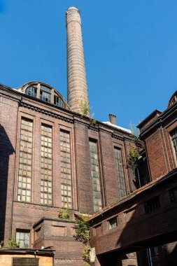Tarihi endüstriyel mimariyi gösteren endüstriyel baca ve tuğla fabrikasının alçak açılı görüntüsü