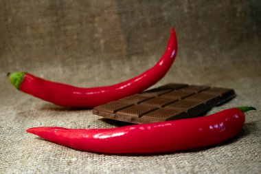 Sert çuval bezine karşı kırmızı kırmızı kırmızı biber ve kırık çikolata.