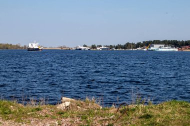 Uzakta ışık dalgaları ve eğlence yatlarıyla su yüzeyinin görüntüsü