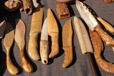 Açık hava köyü fuarında dekoratif ahşap el yapımı bıçaklarla dolu bir ticaret çadırı.