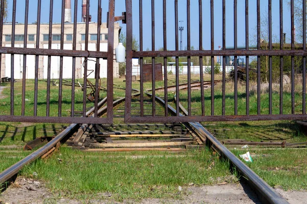 Stary Opuszczony Tor Kolejowy Wchodzi Perspektywę Zardzewiałą Bramą — Zdjęcie stockowe