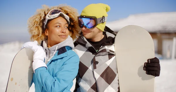 Jeune couple posant avec des snowboards — Photo