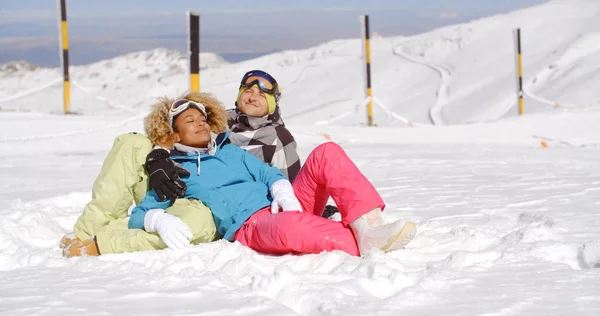 Casal descansando na colina depois de esquiar — Fotografia de Stock