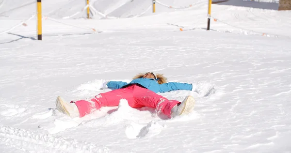 Mujer haciendo ángel en blanco nieve —  Fotos de Stock