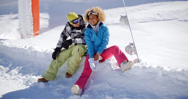 Pareja sentada en un profundo estante de nieve — Foto de Stock