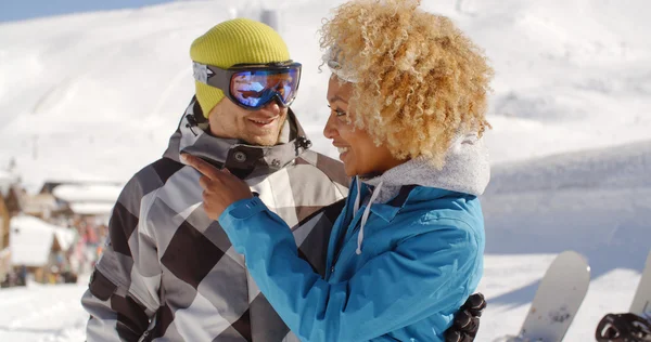 Homem flertando com mulher segurando snowboard — Fotografia de Stock