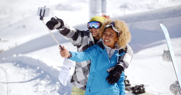 Divertido casal posando na neve para selfie — Fotografia de Stock