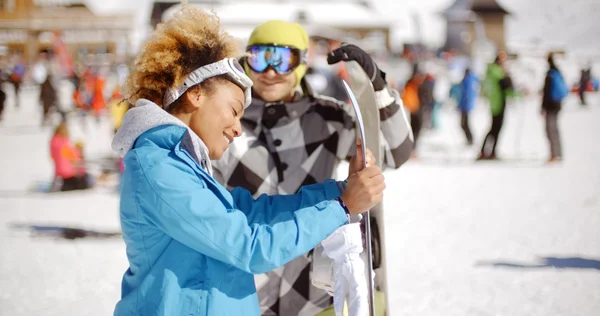 Чоловік фліртує з жінкою, тримаючи сноуборд — стокове фото
