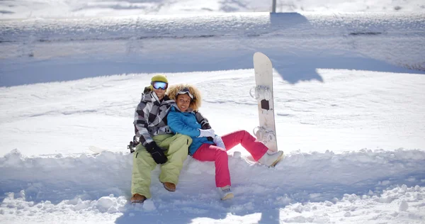 Casal sentado na prateleira profunda de neve — Fotografia de Stock