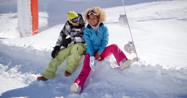 Pareja sentada en un profundo estante de nieve — Vídeos de Stock