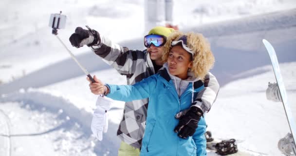 Divertido casal posando na neve para selfie — Vídeo de Stock