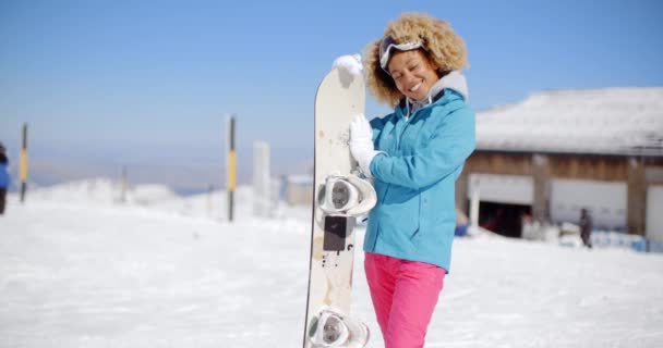 Jonge vrouw met snowboard glimlachen — Stockvideo