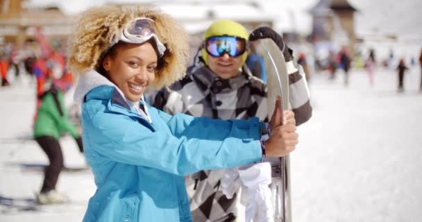 Мужчина флиртует с женщиной, держащей сноуборд — стоковое видео