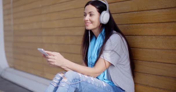 Mujer disfrutando de música en el teléfono móvil — Vídeos de Stock