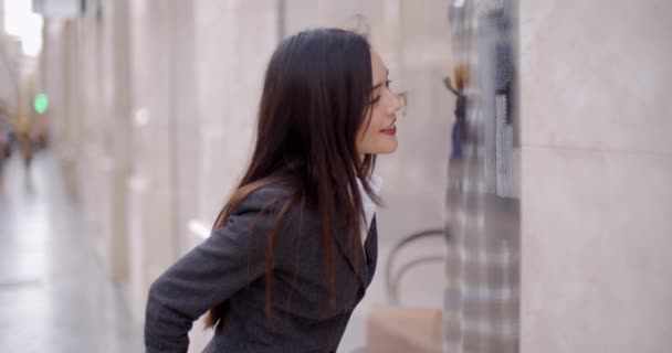 Mujer cerca de la ventana de compras en la ciudad — Vídeos de Stock