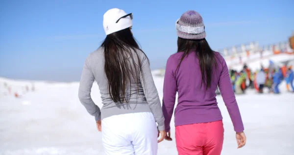 Women walking in snow at ski resort — Stockfoto