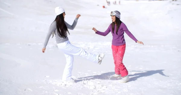 Женщины резвятся в снегу на зимнем курорте — стоковое фото