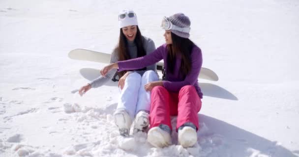 Mujeres jóvenes sentadas y charlando en la nieve — Vídeo de stock