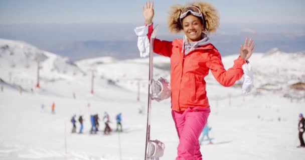 Gülümseyen genç kadın snowboard taşıyan — Stok video