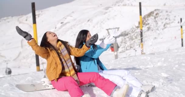 Mujeres sentadas en la cima de la montaña en nieve — Vídeo de stock