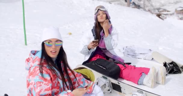 Mujeres sentadas en la cima de la montaña en nieve — Vídeos de Stock